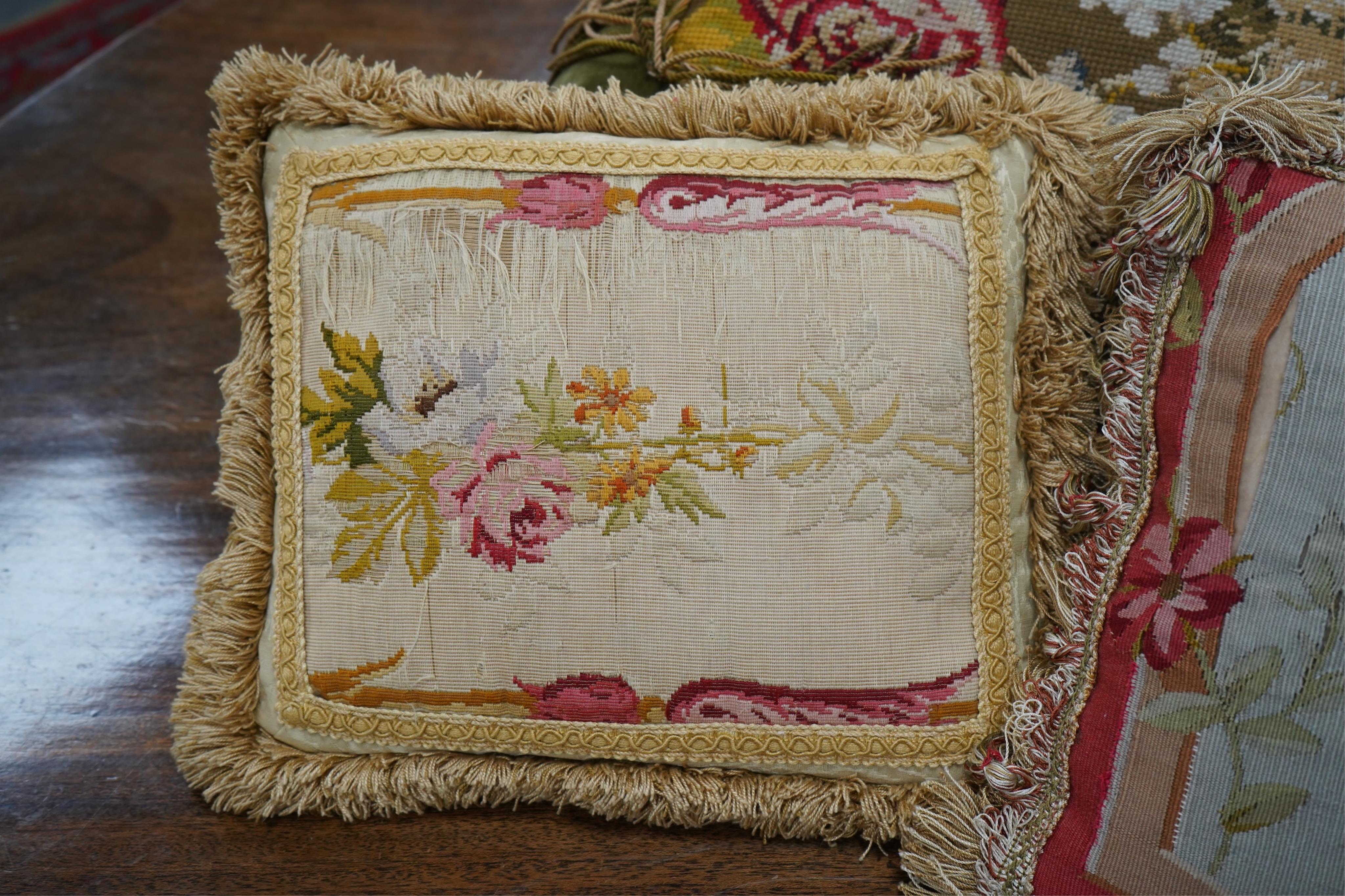 Seven 19th century cushions. Three Aubusson tapestry cushions and two machine Aubusson cushions, together with two floral wool worked cushions, all with decorative fringing. Largest 40cm x 45cm. condition - three are wor